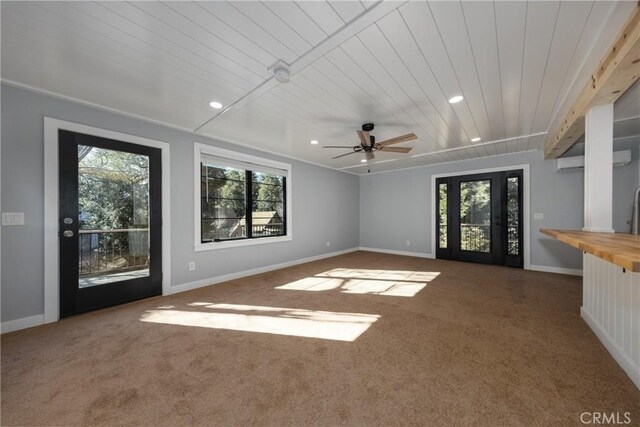 unfurnished living room featuring carpet, ceiling fan, and wooden ceiling