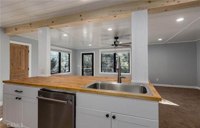 kitchen featuring stainless steel dishwasher, butcher block countertops, sink, and carpet flooring