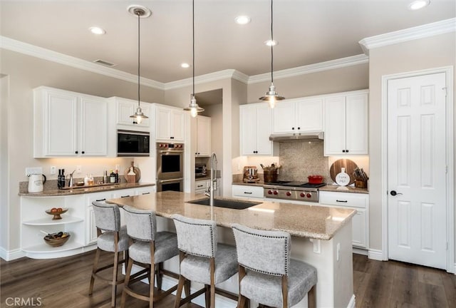 kitchen with white cabinetry, a kitchen island with sink, and decorative light fixtures