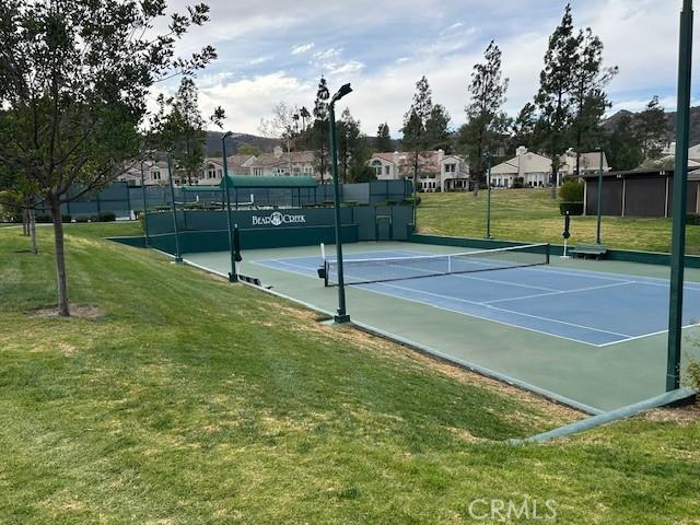 view of sport court with a lawn