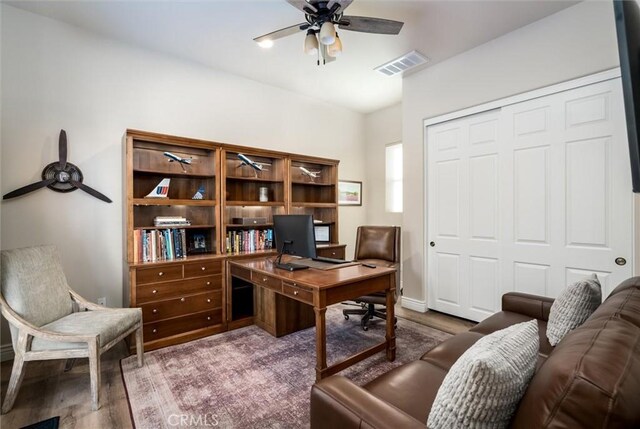 home office with wood-type flooring and ceiling fan