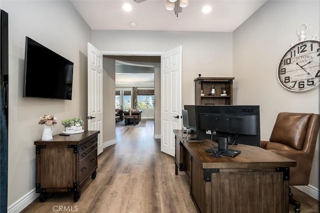 office featuring ceiling fan and light hardwood / wood-style flooring