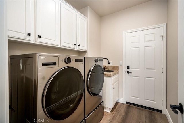 washroom featuring dark wood-type flooring, cabinets, separate washer and dryer, and sink