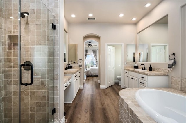 full bathroom featuring hardwood / wood-style flooring, vanity, ceiling fan, and toilet