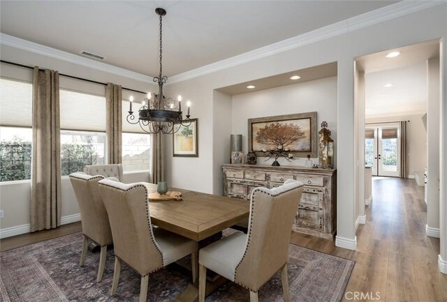 dining area with hardwood / wood-style flooring and ornamental molding