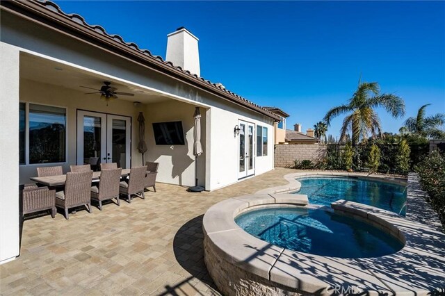 view of swimming pool with a patio area, french doors, ceiling fan, and an in ground hot tub