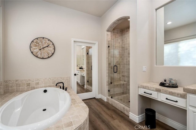 bathroom with vanity, shower with separate bathtub, and hardwood / wood-style floors