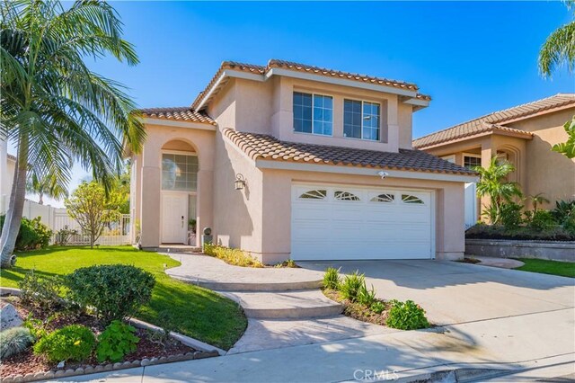 mediterranean / spanish-style house featuring a garage and a front yard