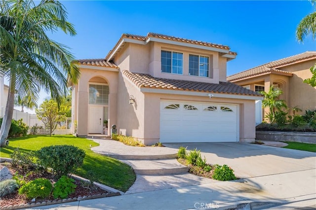 mediterranean / spanish house featuring an attached garage, fence, driveway, a tiled roof, and stucco siding