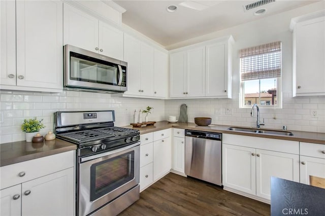 kitchen with tasteful backsplash, sink, stainless steel appliances, and white cabinetry