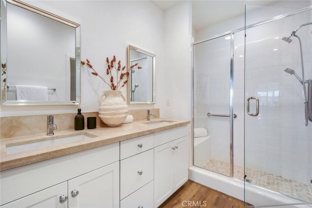 bathroom featuring vanity, wood-type flooring, and a shower with door