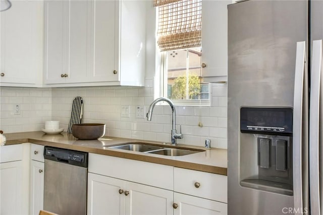 kitchen with sink, white cabinets, stainless steel appliances, and tasteful backsplash