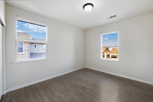 unfurnished room with plenty of natural light and dark hardwood / wood-style flooring