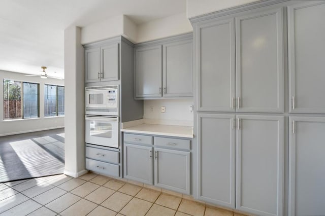 kitchen featuring ceiling fan, white appliances, light tile patterned floors, and gray cabinetry