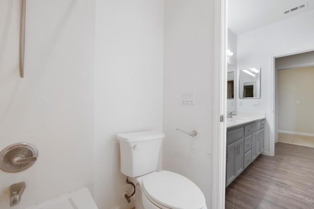 bathroom featuring toilet, vanity, and hardwood / wood-style floors