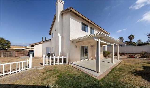 back of house featuring a pergola, a patio area, and a yard