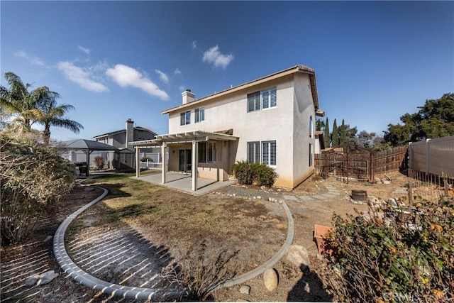 rear view of property featuring a gazebo, a pergola, and a patio