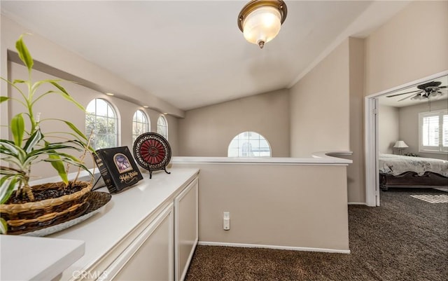 interior space with vaulted ceiling and dark colored carpet