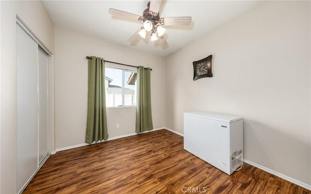 unfurnished bedroom featuring ceiling fan, dark hardwood / wood-style flooring, a closet, and fridge