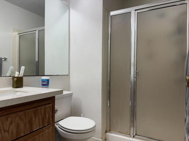 bathroom featuring vanity, toilet, and a shower with door