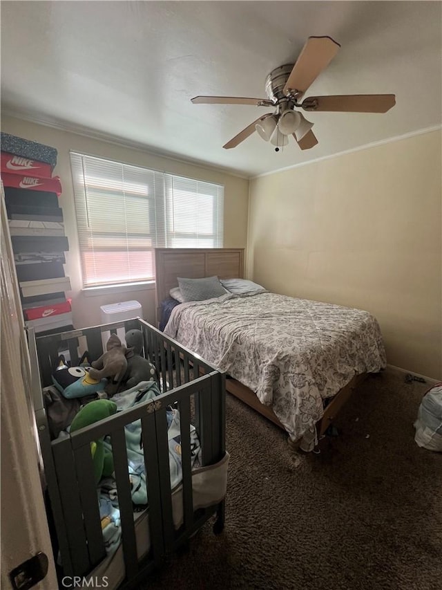 carpeted bedroom featuring ornamental molding and ceiling fan