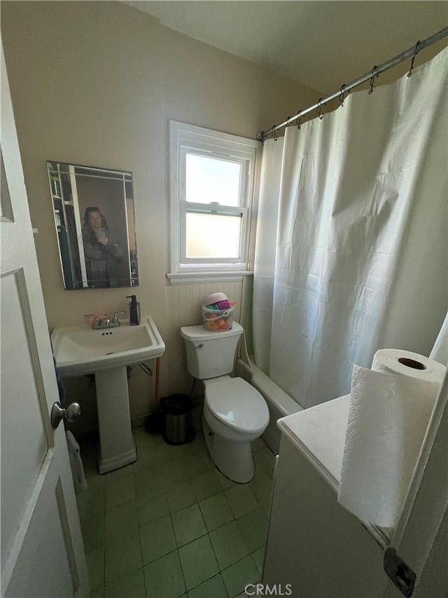 full bathroom featuring tile patterned flooring, sink, shower / bath combination with curtain, and toilet