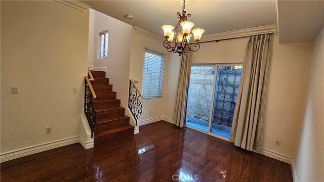 interior space featuring dark wood-type flooring, a chandelier, and crown molding