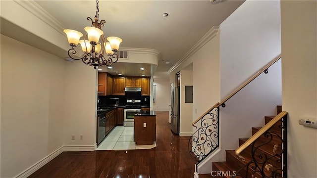 kitchen with decorative backsplash, appliances with stainless steel finishes, crown molding, and a notable chandelier