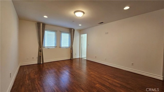 unfurnished room featuring dark hardwood / wood-style flooring and a baseboard radiator