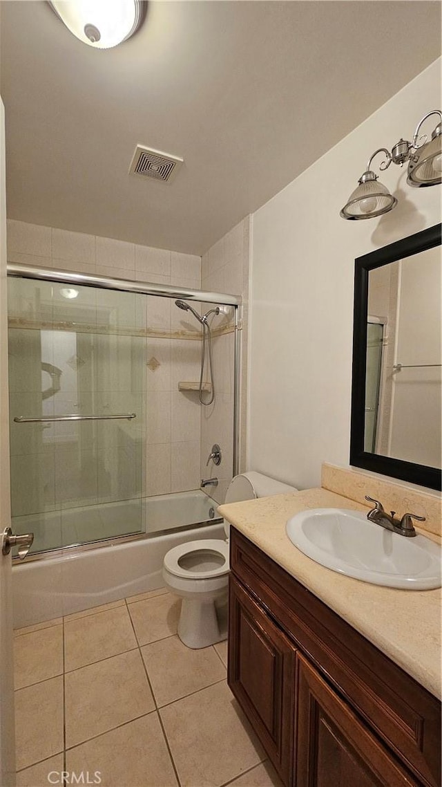 full bathroom with enclosed tub / shower combo, vanity, toilet, and tile patterned flooring