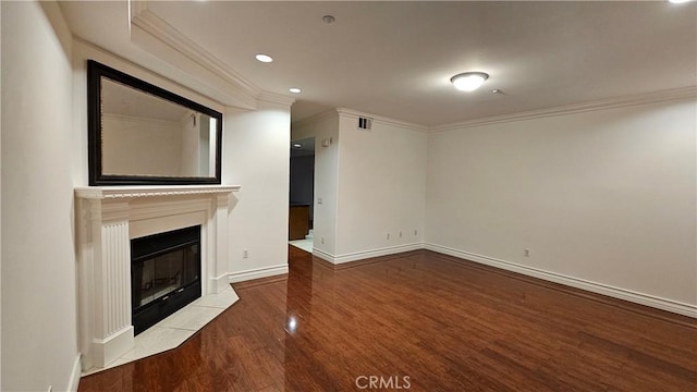 unfurnished living room with hardwood / wood-style flooring, a tile fireplace, and ornamental molding