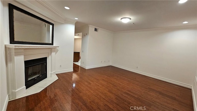 unfurnished living room featuring wood-type flooring, a fireplace, and crown molding