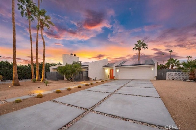 view of front of property with solar panels and a garage