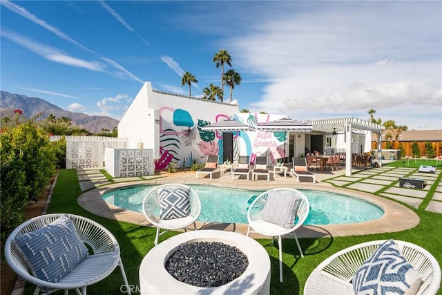 back of property featuring a pergola, a patio area, a mountain view, and an outdoor fire pit