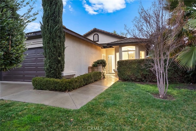 view of front of property with a garage and a front lawn