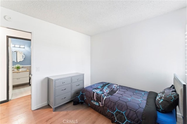 bedroom featuring a textured ceiling and light hardwood / wood-style flooring