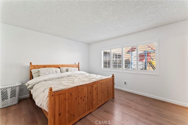 bedroom featuring hardwood / wood-style flooring and a textured ceiling