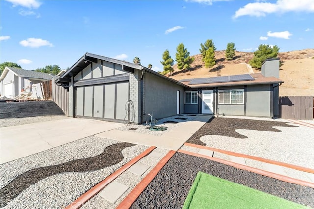 view of front of home featuring a garage and solar panels