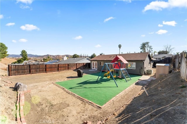 view of jungle gym with a mountain view and a patio area