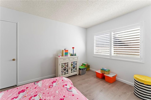 bedroom with a textured ceiling and light hardwood / wood-style floors