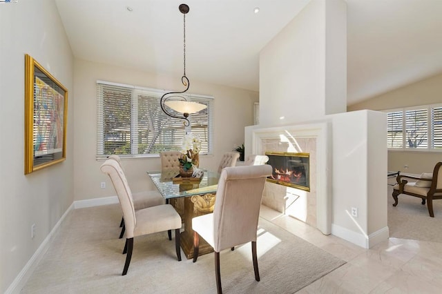 dining space with lofted ceiling and a fireplace