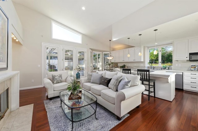 living room featuring a high end fireplace, a wealth of natural light, french doors, and wood-type flooring