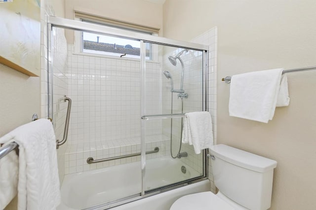 bathroom with combined bath / shower with glass door and toilet