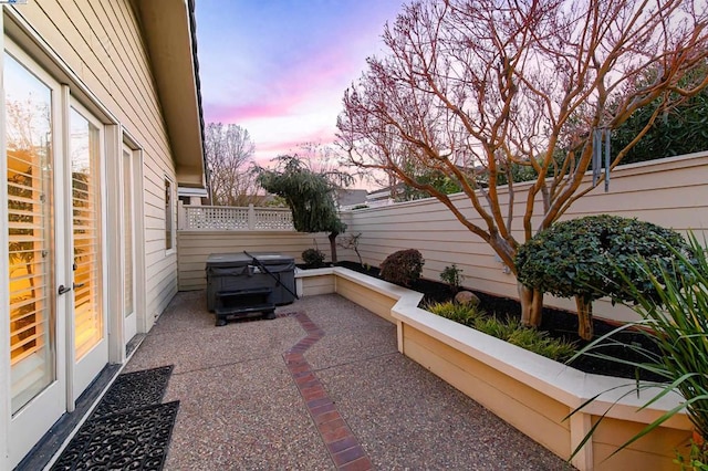 patio terrace at dusk featuring grilling area