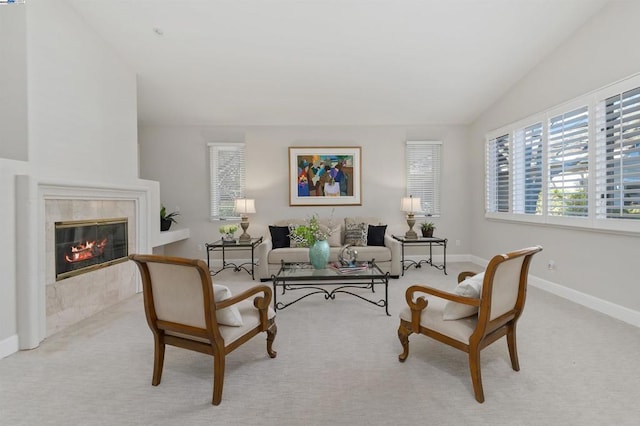 carpeted living room with vaulted ceiling and a tile fireplace