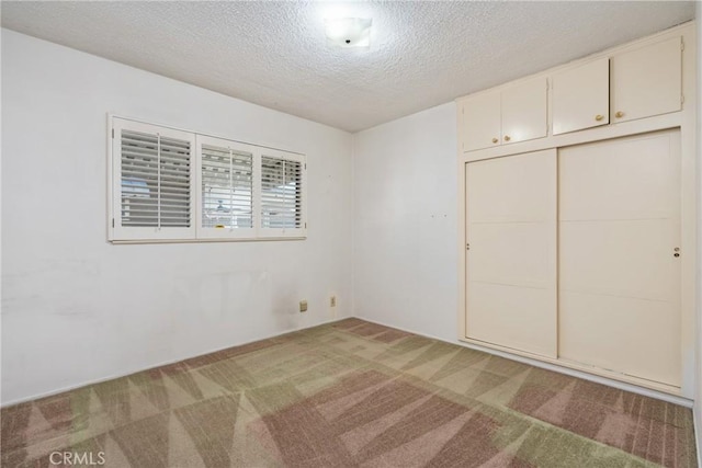 unfurnished bedroom with a textured ceiling, a closet, and light carpet