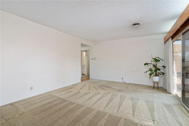 carpeted empty room with a textured ceiling