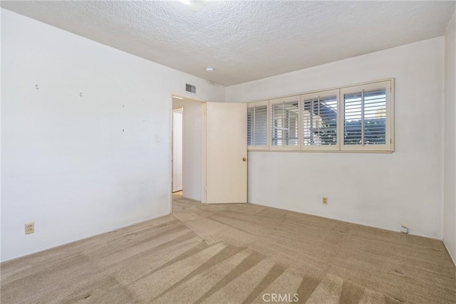 carpeted spare room featuring a textured ceiling