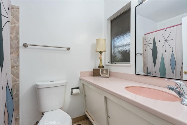 bathroom featuring toilet, vanity, and a shower with shower curtain