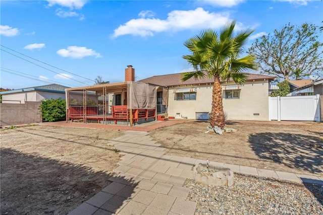 rear view of property with a wooden deck and a patio